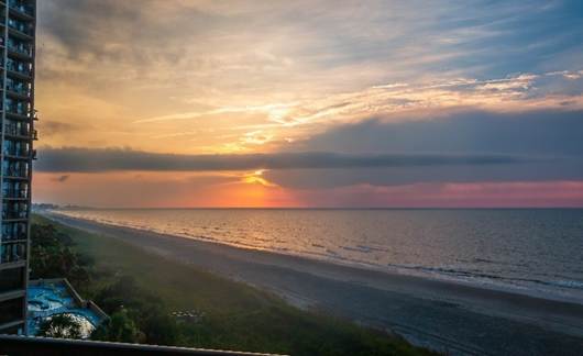 A sunset over a beach

Description automatically generated